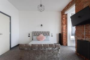 a bedroom with a bed and a brick wall at RESIDENCY LUXURY SEAFRONT HOTEL in Blackpool