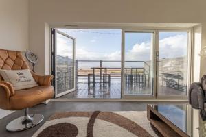 a living room with a couch and a large window at RESIDENCY LUXURY SEAFRONT HOTEL in Blackpool