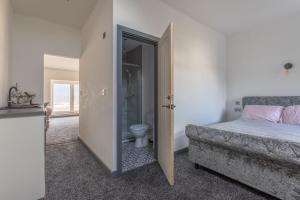 a bedroom with a bed and a bathroom with a toilet at RESIDENCY LUXURY SEAFRONT HOTEL in Blackpool