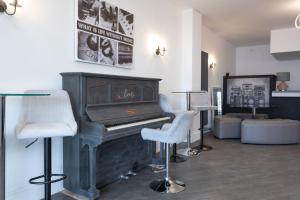 a living room with a piano and two chairs at RESIDENCY LUXURY SEAFRONT HOTEL in Blackpool