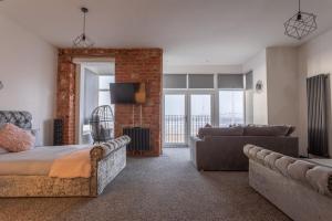a bedroom with a bed and a living room with a couch at RESIDENCY LUXURY SEAFRONT HOTEL in Blackpool