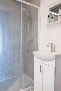 a white bathroom with a shower and a sink at RESIDENCY LUXURY SEAFRONT HOTEL in Blackpool