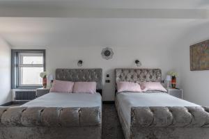 a bedroom with two beds and a couch at RESIDENCY LUXURY SEAFRONT HOTEL in Blackpool