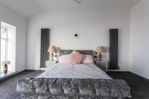 a bedroom with a large bed with pink pillows at RESIDENCY LUXURY SEAFRONT HOTEL in Blackpool