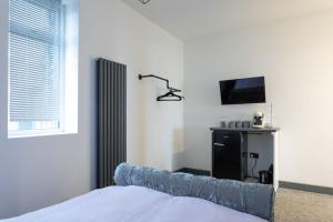 a bedroom with a bed and a tv on a wall at RESIDENCY LUXURY SEAFRONT HOTEL in Blackpool