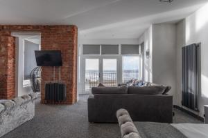 a living room with a couch and a brick wall at RESIDENCY LUXURY SEAFRONT HOTEL in Blackpool