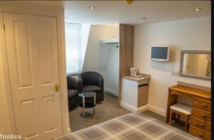 a hotel room with a desk and a television and a room at Weymouth Bay Hotel in Weymouth