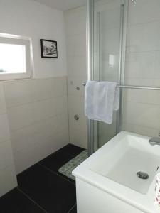 a white bathroom with a sink and a shower at Das Lupinchen in Neuss