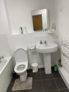 a white bathroom with a toilet and a sink at Eaglet 2 Bedroom Luxury Home near Etihad Staduim in Manchester