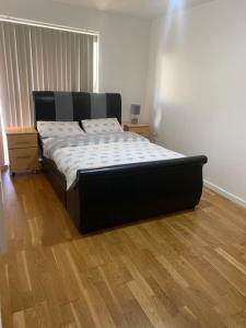 a bed in a room with a wooden floor at Eaglet 2 Bedroom Luxury Home near Etihad Staduim in Manchester