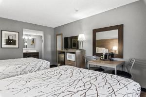 a hotel room with two beds and a desk and a mirror at GreenTree Inn Prescott Valley in Prescott Valley +45 photos