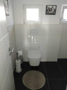 a white bathroom with a toilet and a window at Das Lupinchen in Neuss