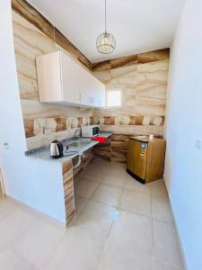a kitchen with white cabinets and a counter top at Dahab Hills Villa and Studios in Dahab