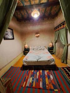 1 dormitorio con cama y alfombra grande en DAR JOUD, en Tabourakht