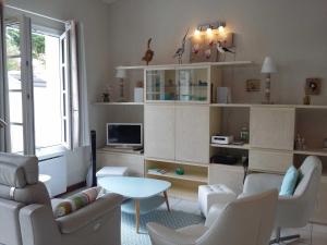 a living room with white chairs and a table at Appartement Saint-Martin-de-Ré, 3 pièces, 4 personnes - FR-1-544-10 in Saint-Martin-de-Ré