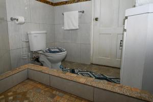 a bathroom with a toilet and a door in it at La Vue in Anse La Raye