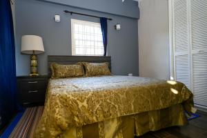 een slaapkamer met een bed met een gele sprei en een raam bij La Vue in Anse La Raye