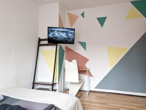een slaapkamer met een kleurrijke muur en een tv. bij 5 Person Vacation Apartment In The Black Forest in Villingen-Schwenningen