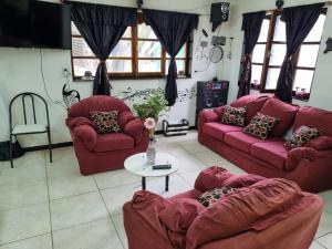 a living room with red couches and a table at Hospedaje Shalom in Ushuaia