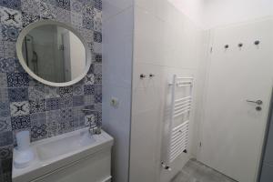 bagno con lavandino bianco e specchio di Cozy Novotel Studio - Free Minibar - Quiet & Peace a Bucarest