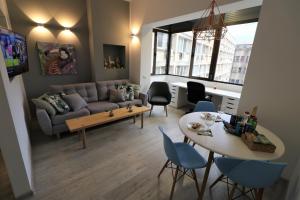 un soggiorno con divano, tavolo e sedie di Cozy Novotel Studio - Free Minibar - Quiet & Peace a Bucarest