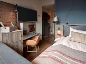 a hotel room with a bed and a desk at Downtown Camper by Scandic in Stockholm