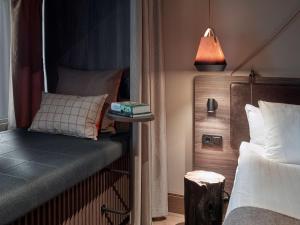 une chambre avec un lit et une table de chevet avec une lampe dans l'établissement Downtown Camper by Scandic, à Stockholm