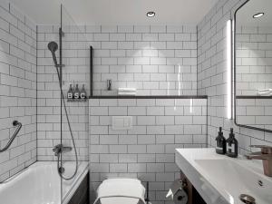a bathroom with a tub and a toilet and a sink at Downtown Camper by Scandic in Stockholm