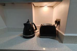 a tea kettle and toaster sitting on a counter at cosy apartment Alexandra palace Haringey, London in London