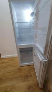 un frigorifero vuoto con la porta aperta in una stanza di cosy apartment Alexandra palace Haringey, London a Londra