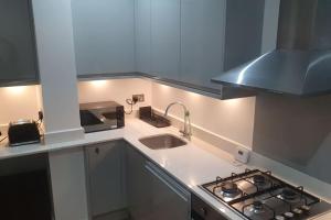 a small kitchen with a sink and a stove at cosy apartment Alexandra palace Haringey, London in London