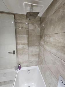 ein Bad mit einer Dusche und einem weißen WC in der Unterkunft cosy apartment Alexandra palace Haringey, London in London