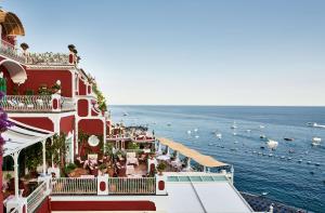 a large red building next to a body of water at Le Sirenuse in Positano