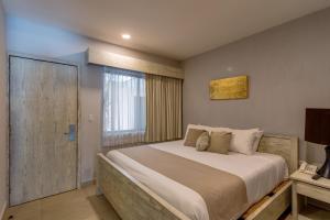 Un dormitorio con una cama grande y una ventana en Aldea Thai by Mistik Vacation Rentals, en Playa del Carmen