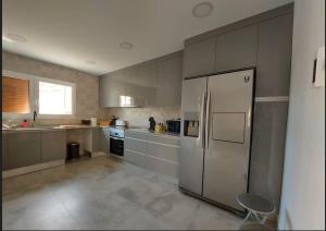 a kitchen with a stainless steel refrigerator and a window at Casa de alquiler Moncófar Playa in Moncófar