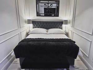 a bed with a black headboard in a room at Hanza Tower Apartament Times Square in Szczecin