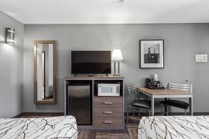 a hotel room with two beds and a desk with a television at GreenTree Inn Prescott Valley in Prescott Valley