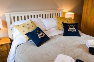 Una cama con almohadas con dos perros. en Hullidays》Marina Town House en Hull