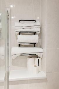 una pila de toallas blancas en un estante del baño en Hullidays》Marina Town House en Hull