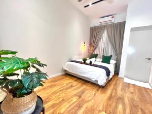 a bedroom with a bed and a potted plant at Luxury 2-Storey Terrace House near IOI City Mall Putrajaya in Putrajaya