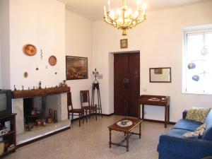 ガルニャーノにあるCasa Vacanze Gargnanoのリビングルーム(青いソファ、暖炉付)