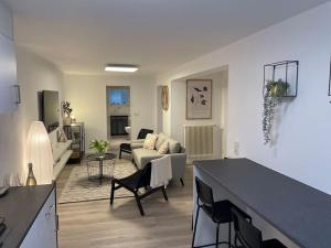 ein weißes Wohnzimmer mit einem Sofa und einem Wohnzimmer in der Unterkunft Gemütliche&Moderne Ferienwohnung Nähe Trier & Luxemburg in Bollendorf
