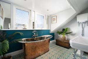 a bathroom with a large copper tub and a sink at Sea View Cottage Dream By The Water in Appledore +25 photos