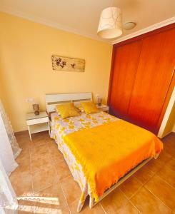 a bedroom with a large bed with a yellow blanket at Apartment in La Tejita 2 in La Tejita