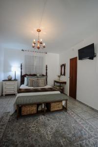 a bedroom with a large bed with a chandelier at Hacienda Tres Casitas in Cabo Rojo