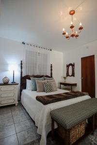 um quarto com uma cama grande e um lustre em Hacienda Tres Casitas em Cabo Rojo