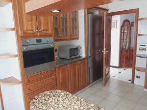 eine Küche mit Holzschränken und einem Kühlschrank aus Edelstahl in der Unterkunft Circ 42 in Santa Pau