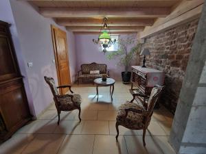 a living room with chairs and a table and a couch at Gîte Taintrux, 5 pièces, 10 personnes - FR-1-589-232 in Taintrux