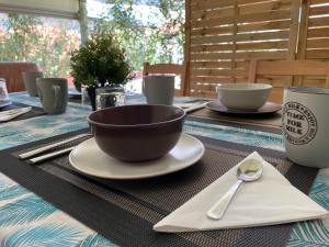 a table with a bowl on a plate with a spoon at Bilocale con terrazza privata - Metro M1 to City Center in Sesto San Giovanni +21 photos