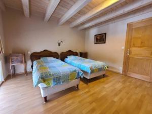 een slaapkamer met 2 bedden en een houten vloer bij Gîte Taintrux, 5 pièces, 10 personnes - FR-1-589-232 in Taintrux